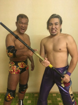 10/26新木場での一騎打ちに向け、田中が菅原にシンガポールケインを手渡す。